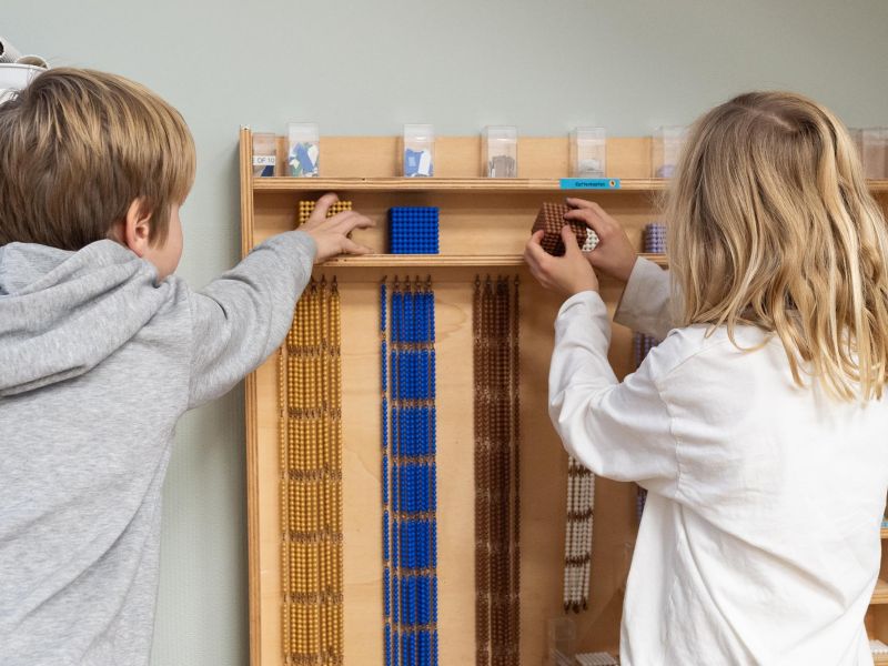 Montessori Lernumgebung, 2 Kinder vor Wand